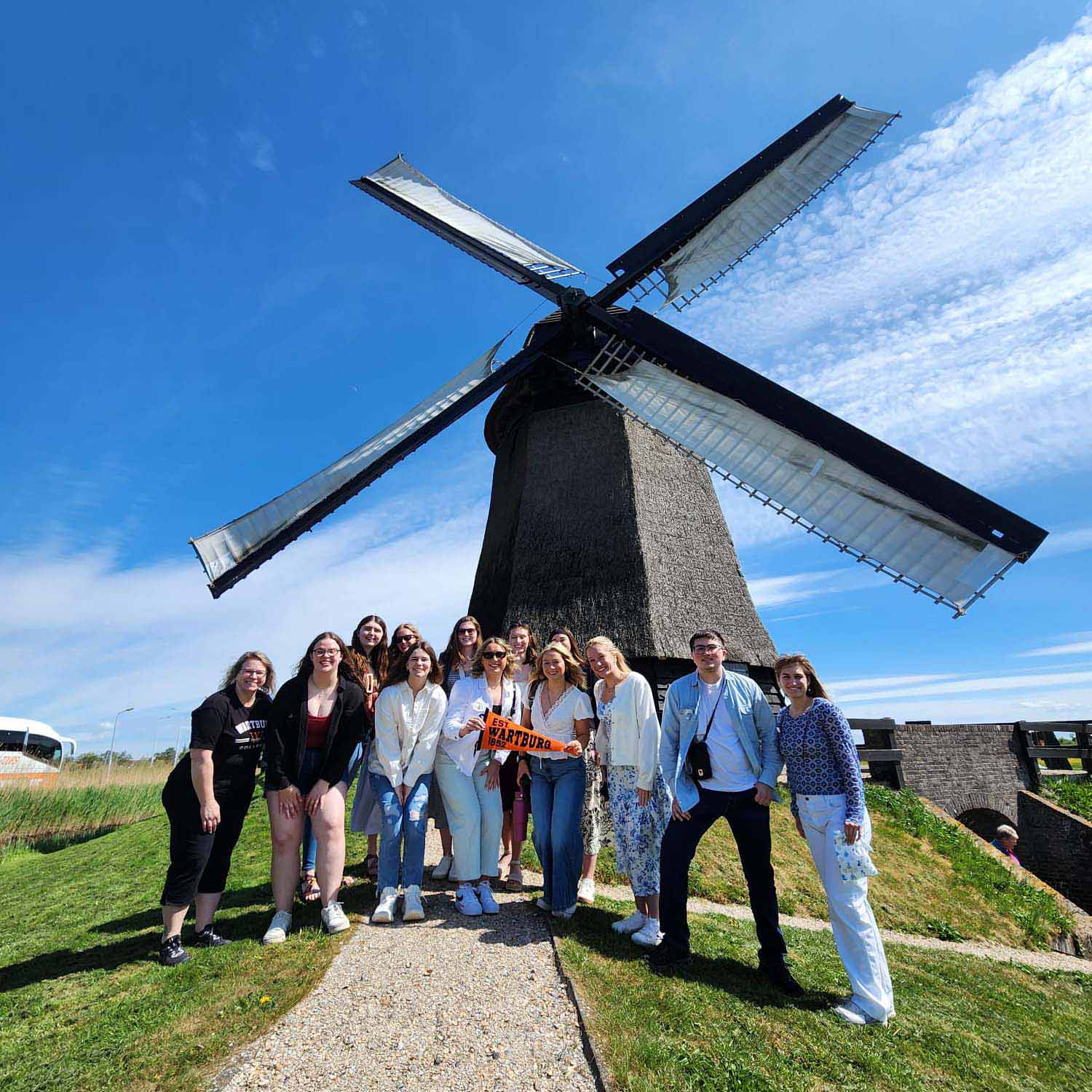 Students stand in front of a windmill in the Netherlands